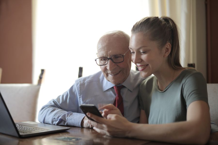 A student helping an older man with his phone